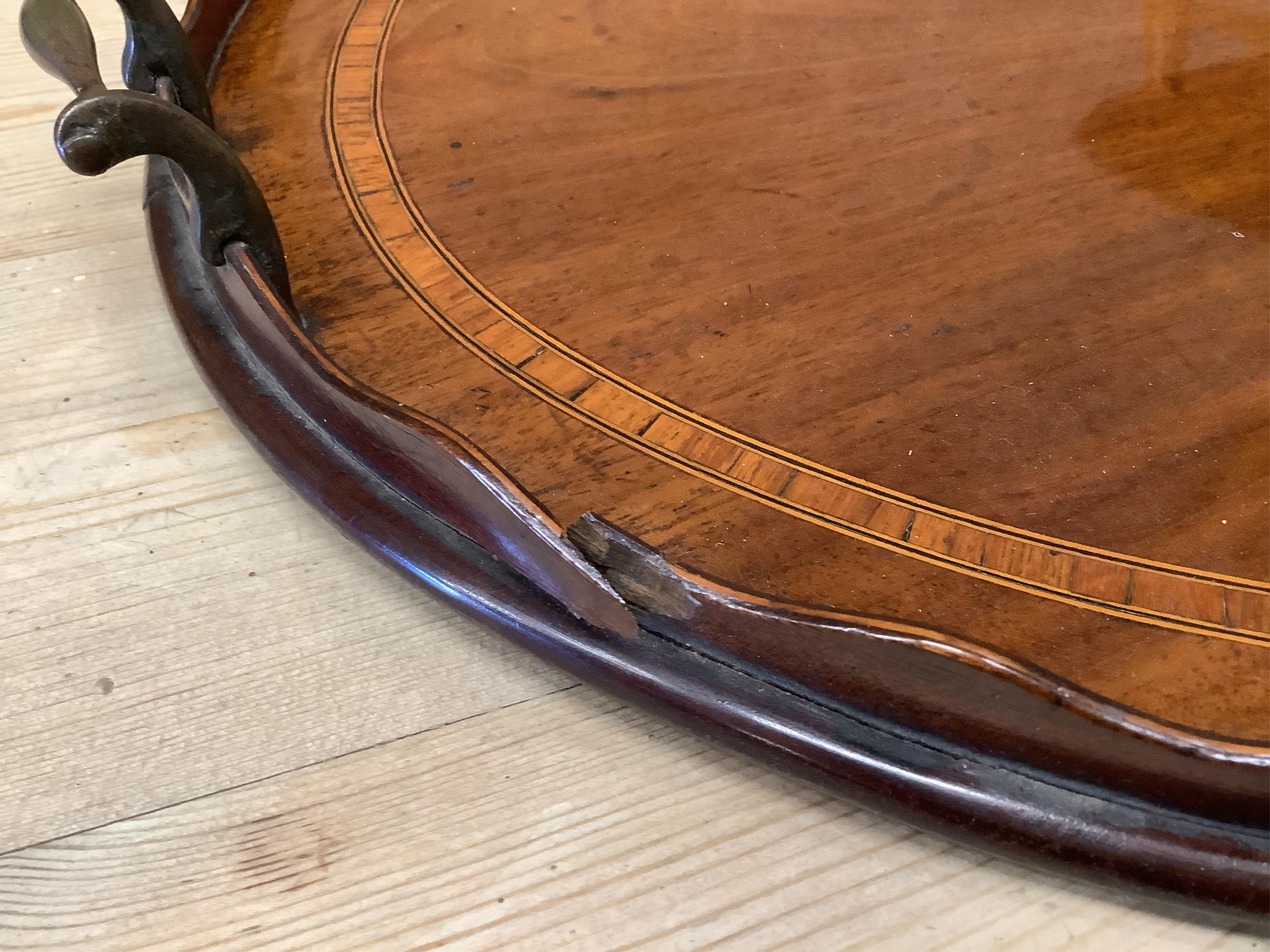 An Edwardian satinwood banded mahogany oval twin handled tea tray, length 73cm, depth 51cm. Condition - poor